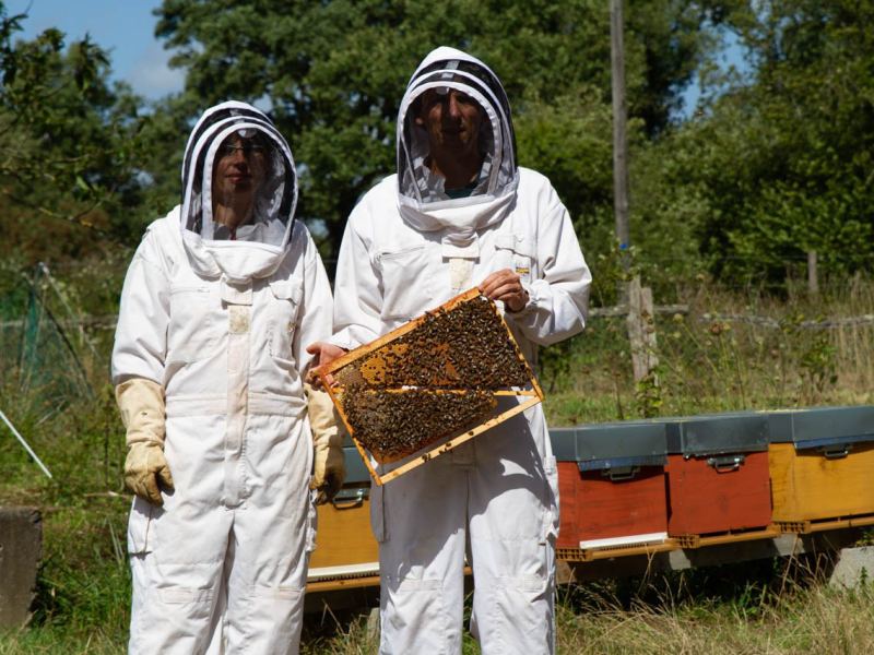 Anne-Laure et Arnaud, apiculteurs du Rucher de La Doue, devant leurs ruches